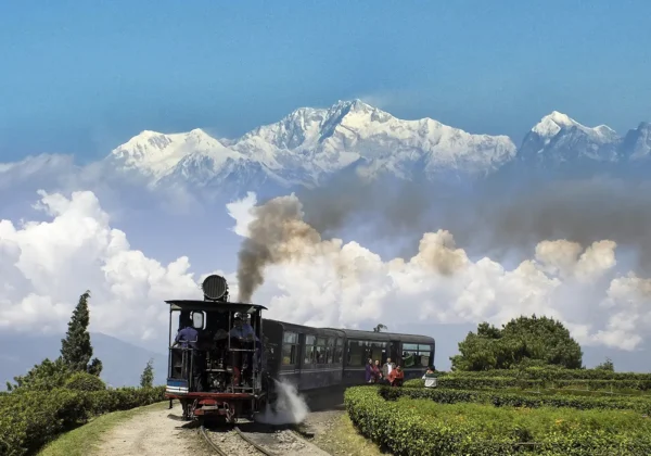 A beautiful picture from Darjeeling showcasing the famous Darjeeling Train and Mt. Kanchenjunga Backdrop.