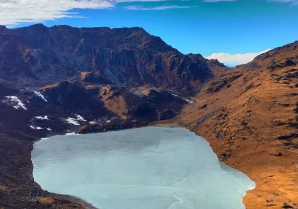 Semi-frozen Lampokhari Lake surrounded by barren mountains on the Kasturi Orar Round Trek.